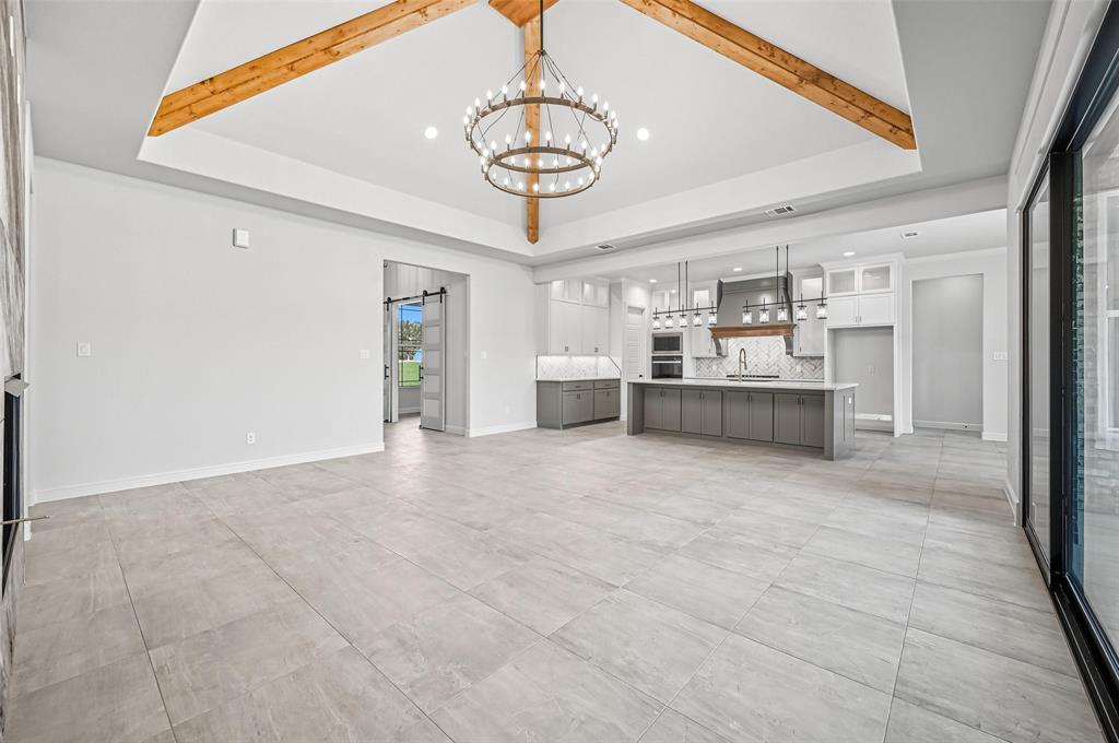 112 La Paloma Way Decatur, TX 76234 - Photo 8 of 37 Unfurnished living room featuring recessed lighting, a chandelier, a tray ceiling, and beam ceiling