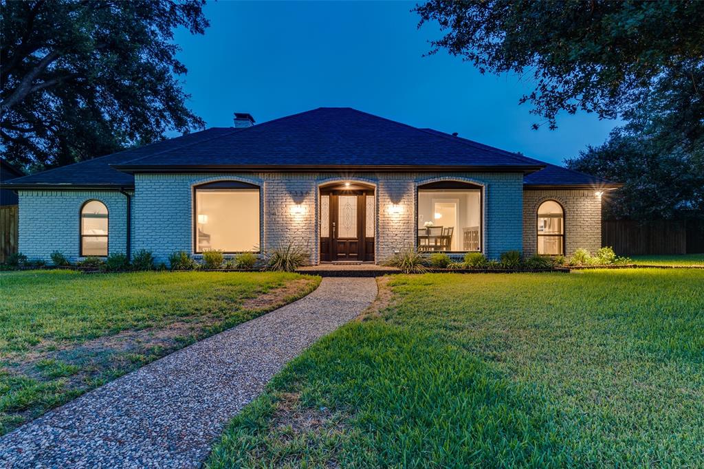 a front view of a house with a garden and yard