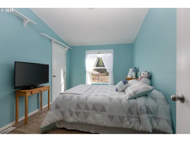 a bedroom with a bed and a flat screen tv