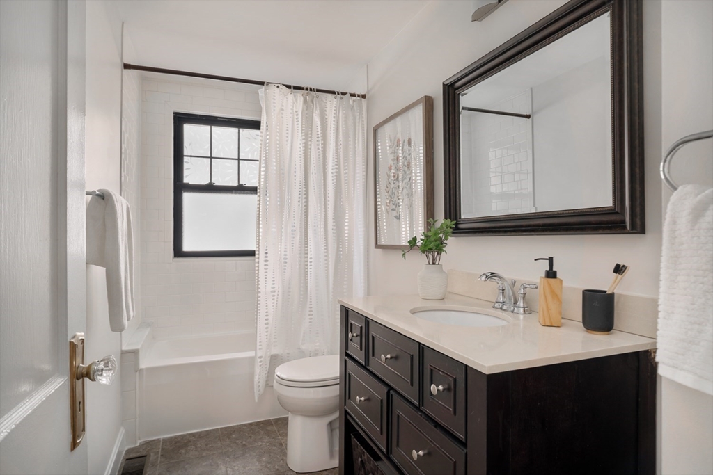 10 Washington Avenue, Unit 2 Waltham, MA 02453 - Photo 17 of 26 a bathroom with a double vanity sink toilet mirror and bathtub