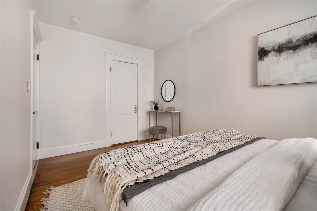 10 Washington Avenue, Unit 2 Waltham, MA 02453 - Photo 19 of 26 a bedroom with a bed and painting on the wall