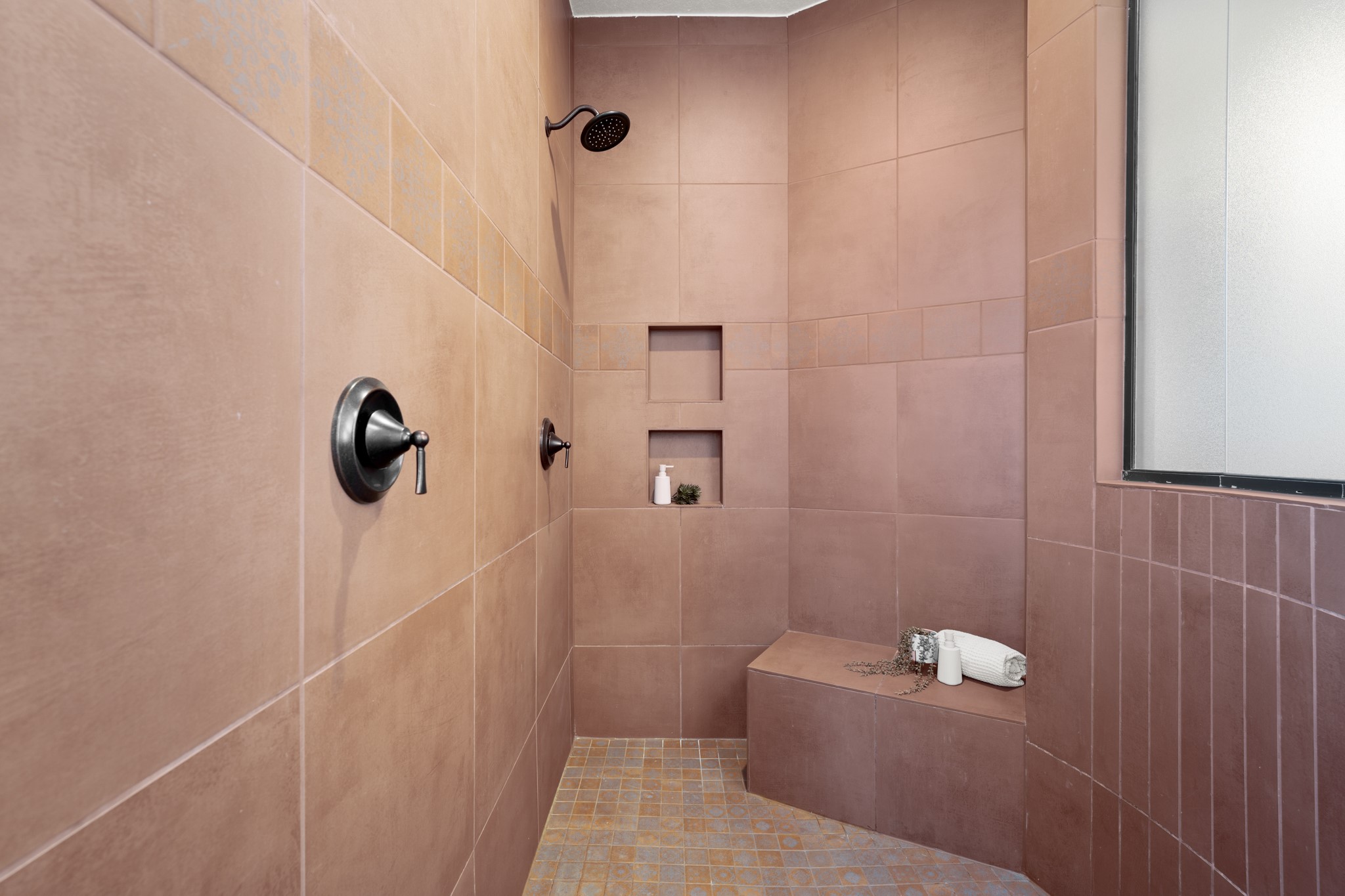 128 Hiram Cook Blanco, TX 78606 - Photo 18 of 40 Tiled shower enclosure featuring bronze-finish fixtures, a built-in bench, dual recessed niches, and a frosted glass window