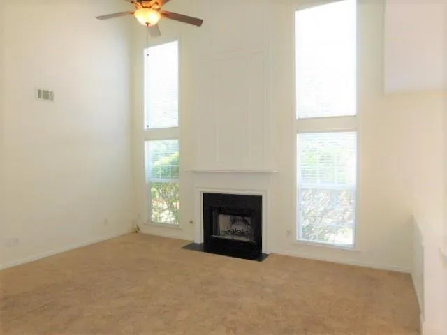an empty room with windows and fireplace