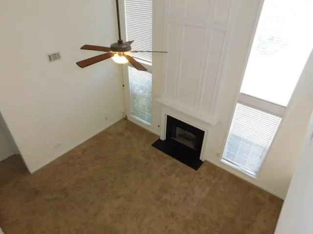 a view of empty room with fireplace and fan