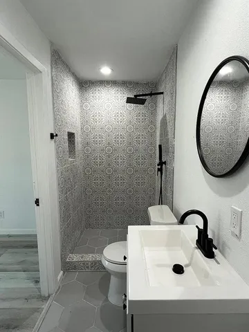 a bathroom with a sink a toilet and shower