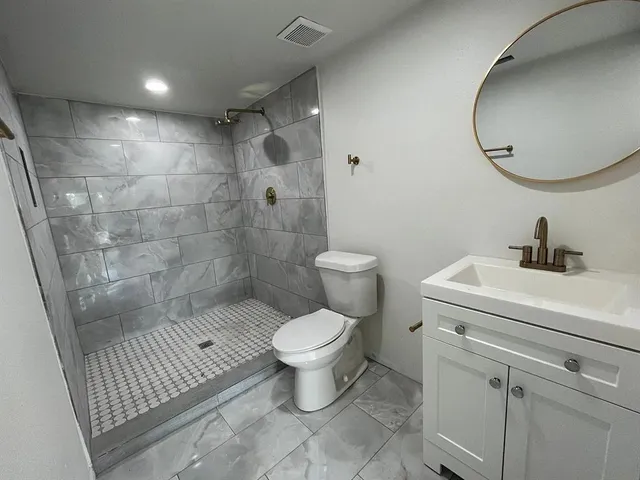 a bathroom with a sink toilet and a mirror