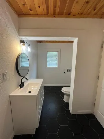 a bathroom with a toilet sink and mirror