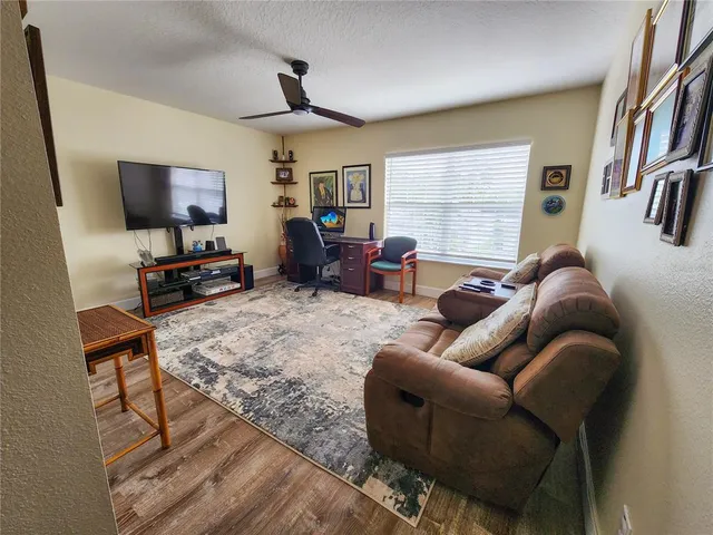 a living room with furniture wooden floor and a flat screen tv