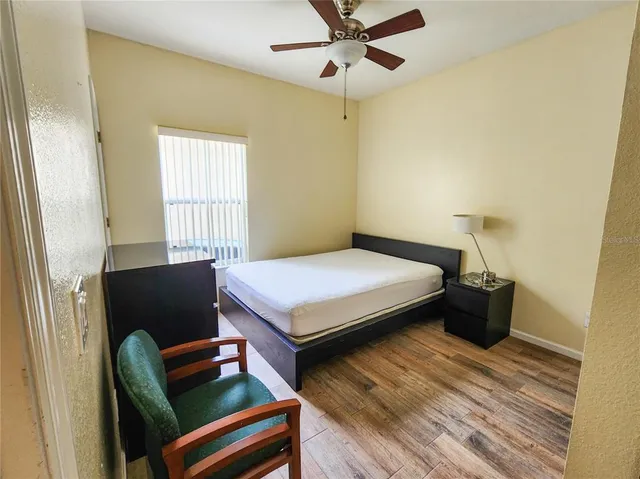 a bedroom with a bed and wooden floor