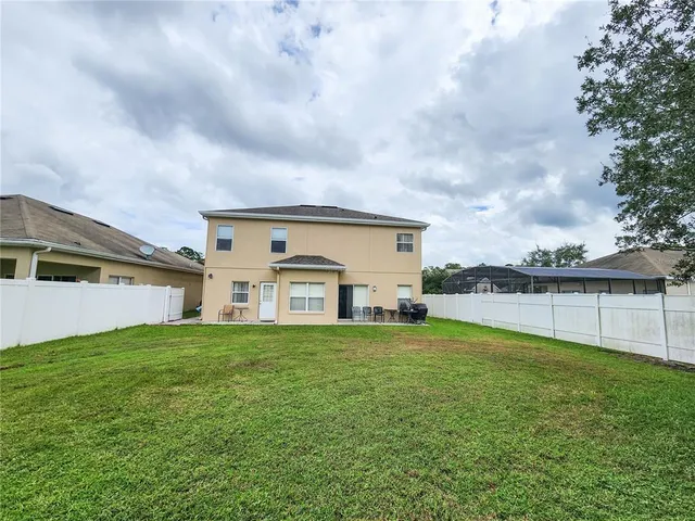 a view of a house with a big yard and a large tree