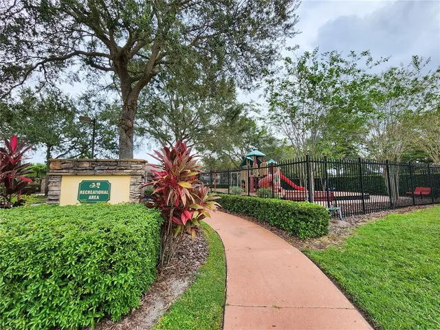 a balcony with table and chairs and potted plants