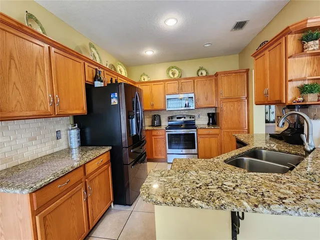 a kitchen with stainless steel appliances granite countertop a sink stove and refrigerator