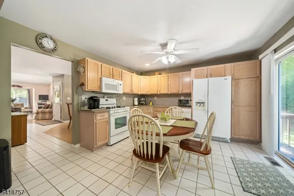 a kitchen with granite countertop cabinets a dining table and appliances