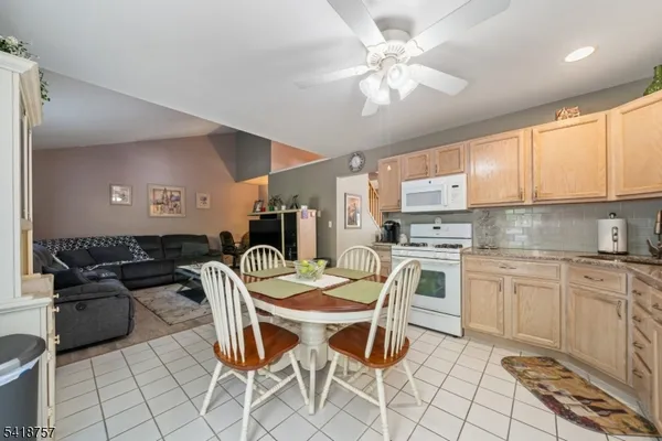 a kitchen with a sink chairs and white appliances