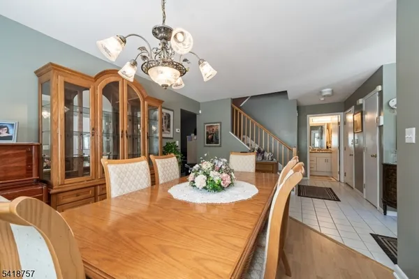 a view of a dining room with furniture a chandelier and wooden floor