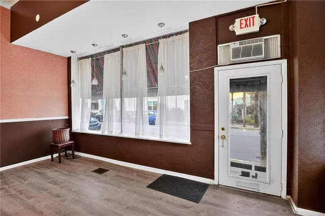 a livingroom with a large window and wooden floor