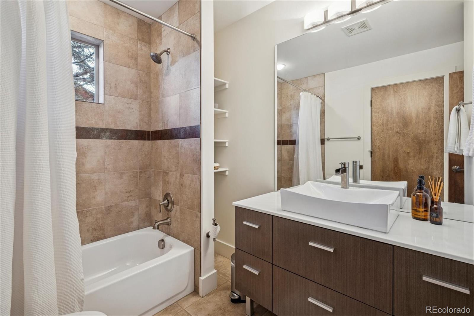 3422 Newton Street Denver, CO 80211 - Photo 14 of 37 a bathroom with a tub sink shower and mirror