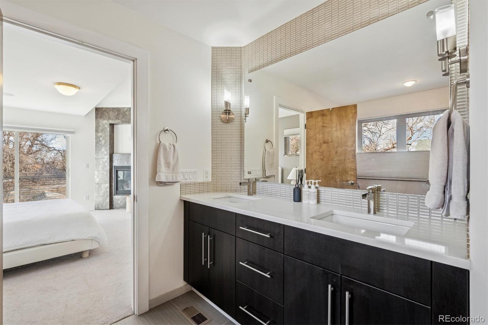 3422 Newton Street Denver, CO 80211 - Photo 17 of 37 a bathroom with a double vanity sink a mirror and a bathtub