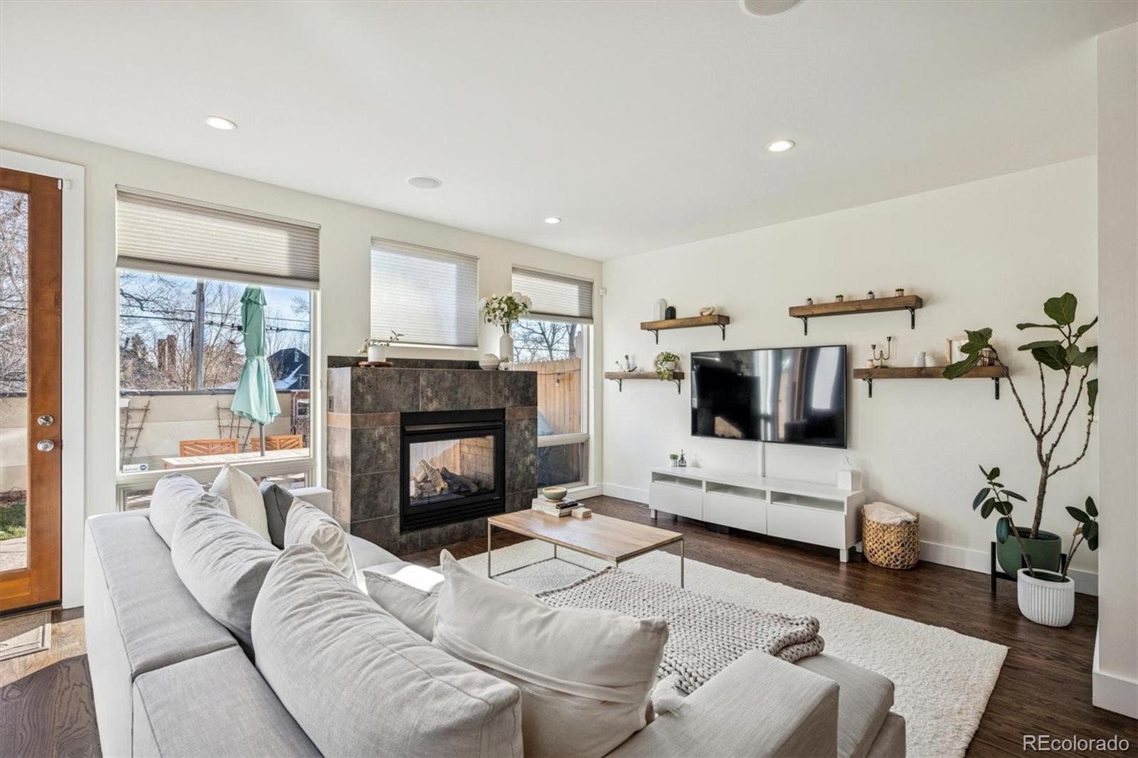 3422 Newton Street Denver, CO 80211 - Photo 4 of 37 a living room with furniture a flat screen tv and a fireplace