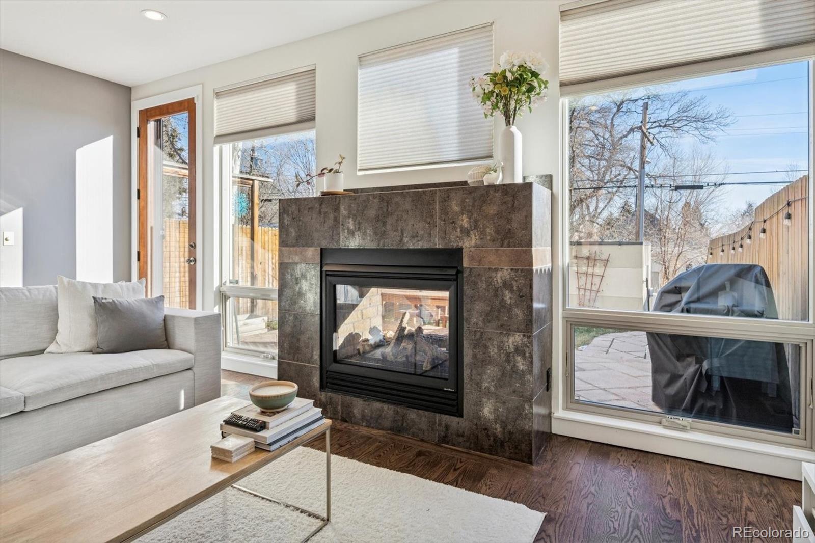 3422 Newton Street Denver, CO 80211 - Photo 6 of 37 a living room with furniture a flat screen tv and a fireplace