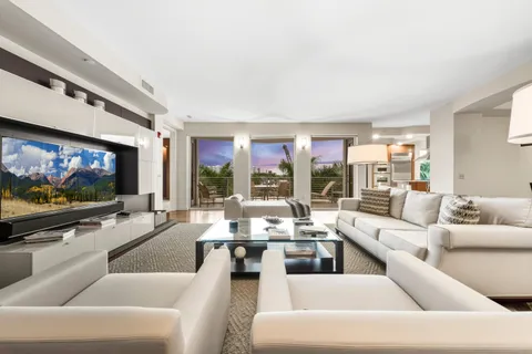 a living room with stainless steel appliances kitchen island granite countertop furniture a rug and a wooden floor