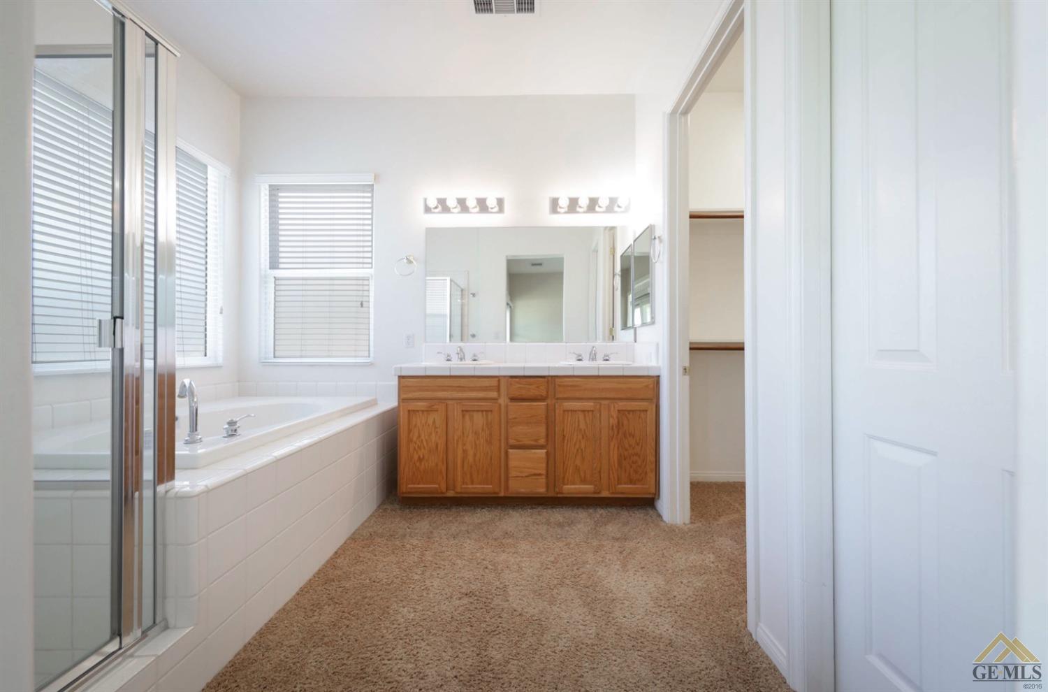 Undisclosed Address Bakersfield, CA 93311 - Photo 13 of 34 a bathroom with a tub sink and mirror