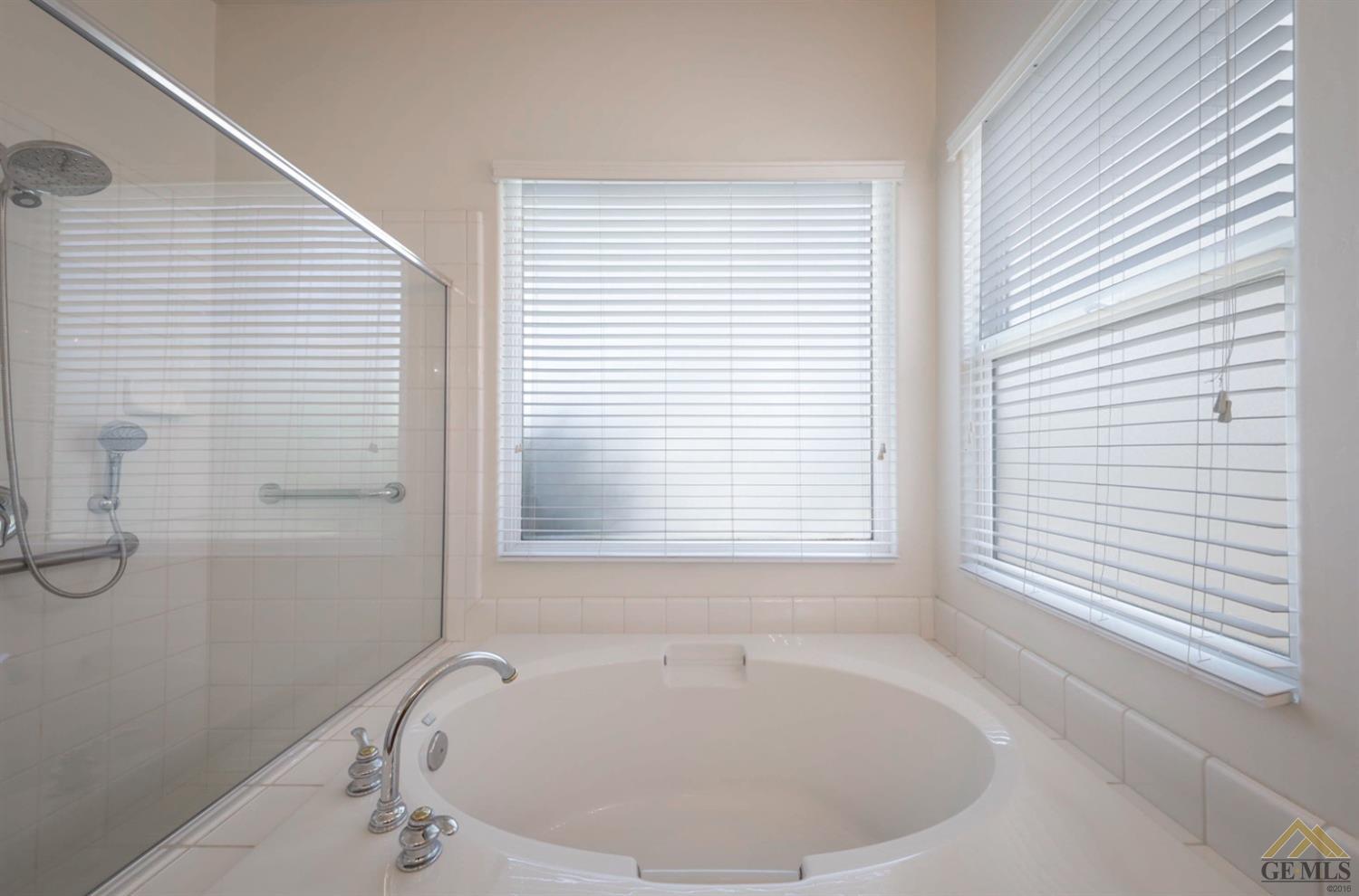 Undisclosed Address Bakersfield, CA 93311 - Photo 15 of 34 a white bath tub sitting in a bathroom next to a window