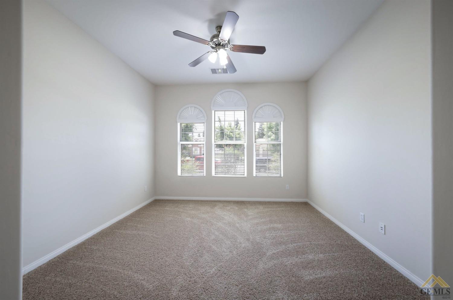 Undisclosed Address Bakersfield, CA 93311 - Photo 25 of 34 an empty room with windows and chandelier fan