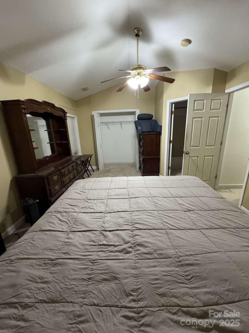 4653 Perkins Road Charlotte, NC 28269 - Photo 13 of 16 a large white bedroom with a bed and a chandelier