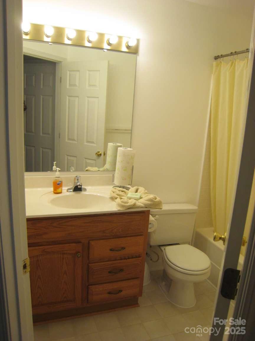 4653 Perkins Road Charlotte, NC 28269 - Photo 16 of 16 a bathroom with a granite countertop toilet a sink and a mirror