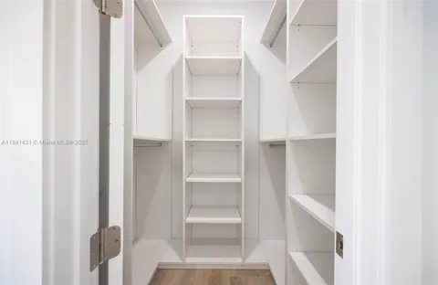 a view of walk in closet with empty racks