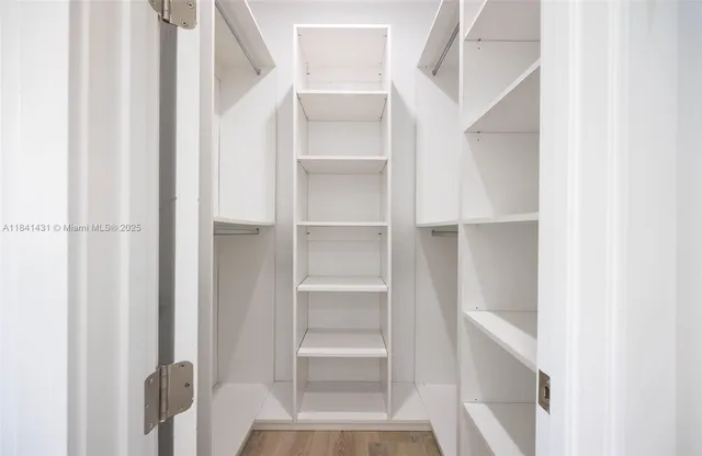 a view of walk in closet with empty racks