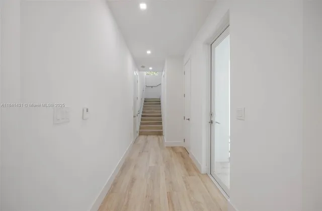 a view of a hallway with wooden floor