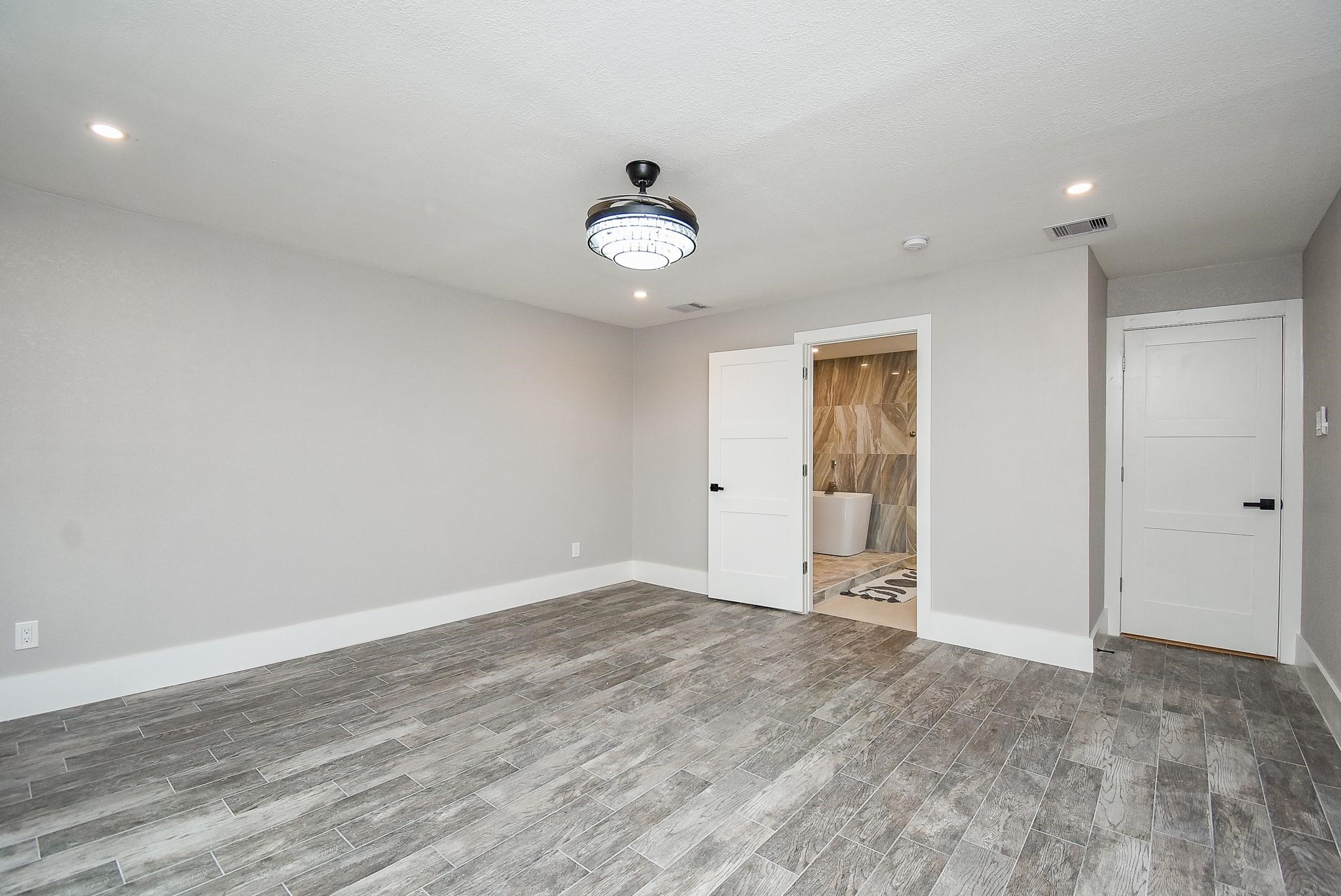 7618 Highmeadow Drive Houston, TX 77063 - Photo 38 of 48 an empty room with wooden floor and windows