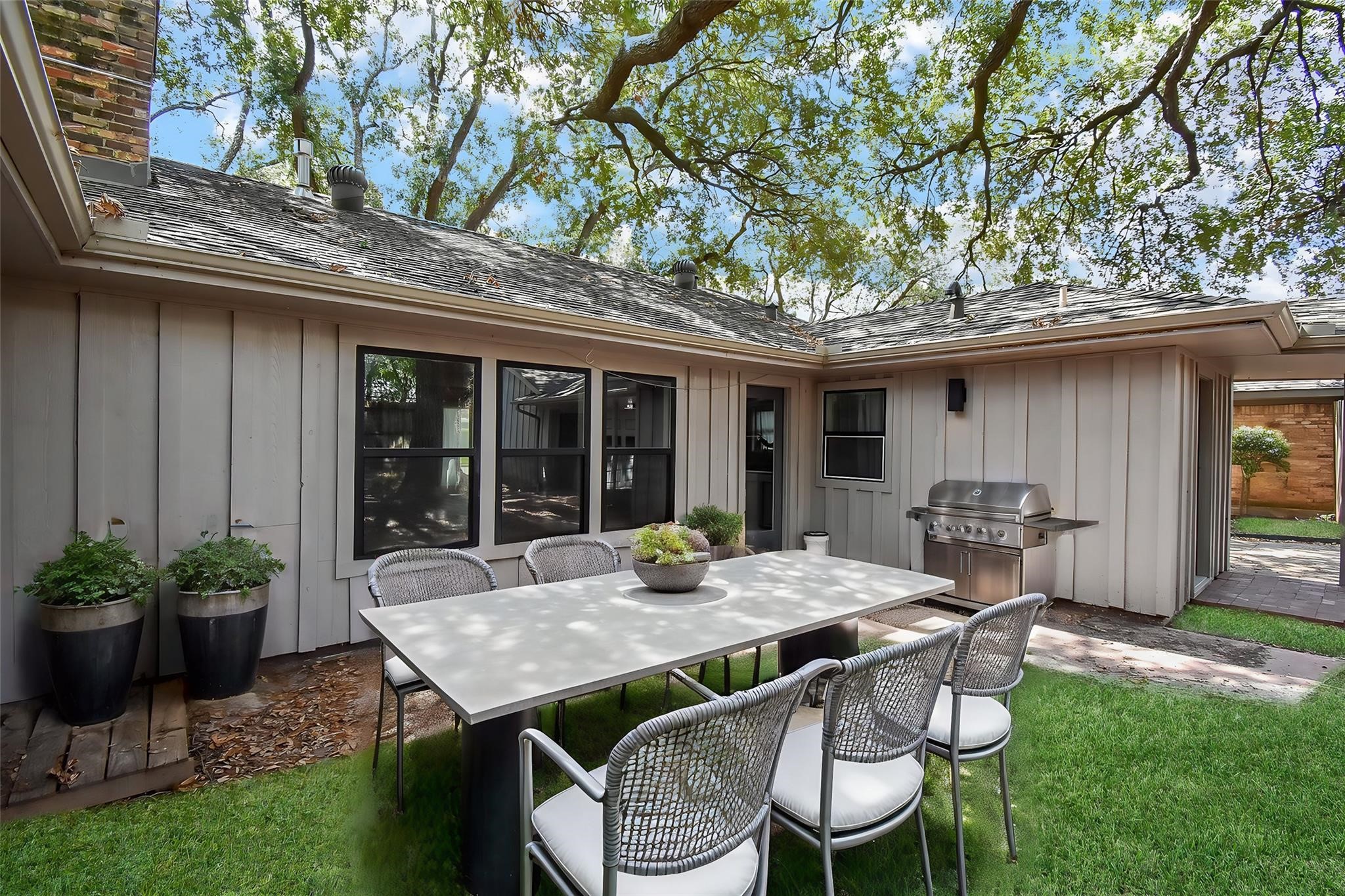 7618 Highmeadow Drive Houston, TX 77063 - Photo 46 of 48 a view of a patio with table and chairs potted plants and large tree