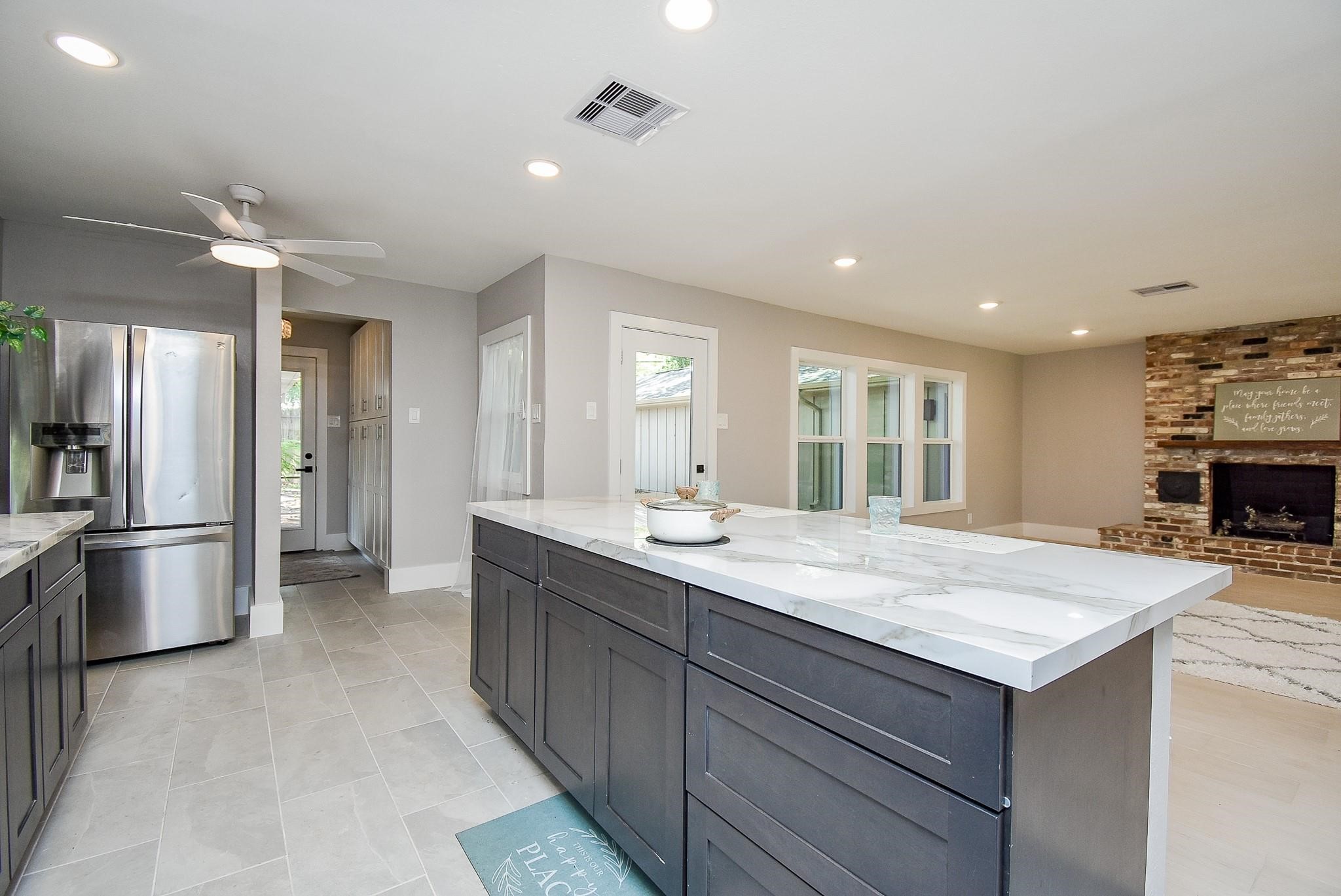 7618 Highmeadow Drive Houston, TX 77063 - Photo 7 of 48 a kitchen with kitchen island a sink stainless steel appliances and refrigerator
