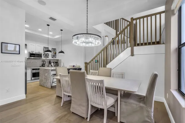 a dining room with furniture a chandelier and wooden floor
