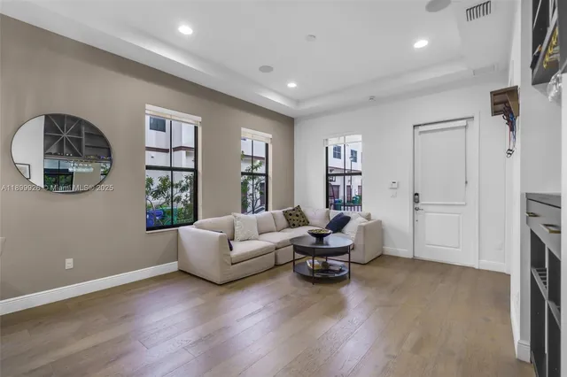 a living room with furniture and a flat screen tv with wooden floor