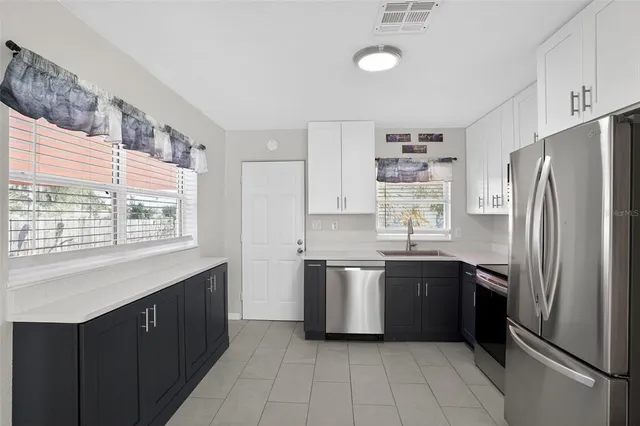 a kitchen with stainless steel appliances granite countertop a refrigerator and a stove top oven