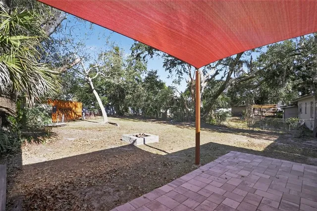 a view of a house with a yard and a large tree