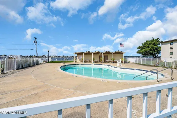a view of pool with brick walls plants and wooden fence