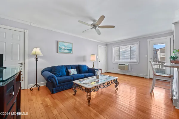 a living room with furniture a ceiling fan and a wooden floor