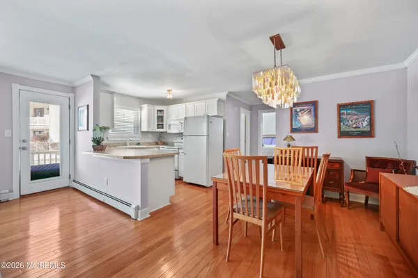a kitchen with stainless steel appliances granite countertop a dining table chairs and a refrigerator