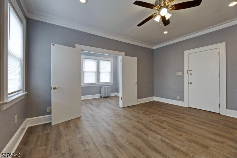 90 Norman Road Newark, NJ 07106 - Photo 14 of 31 an empty room with wooden floor fan and windows