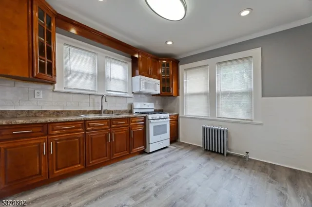a kitchen with granite countertop a stove a sink and a microwave