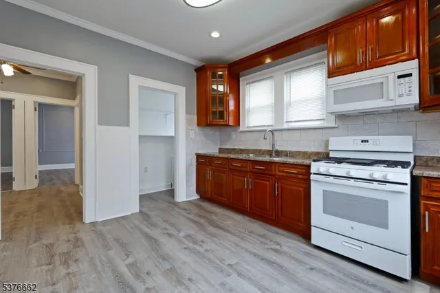 a kitchen with granite countertop wooden cabinets and white appliances