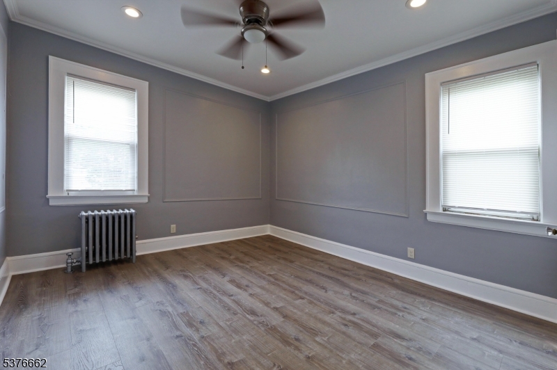 90 Norman Road Newark, NJ 07106 - Photo 28 of 31 an empty room with wooden floor fan and windows