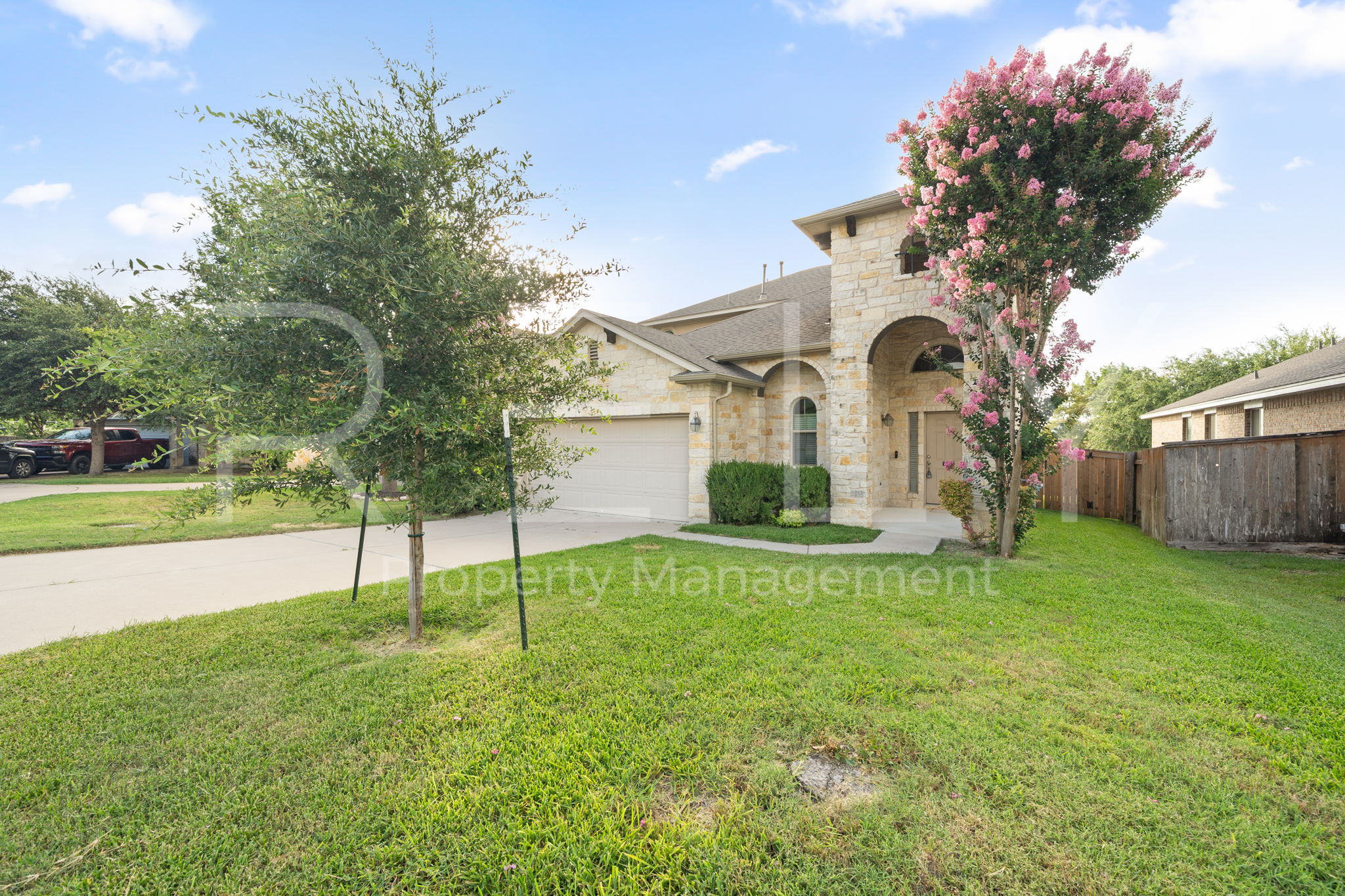1405 Sunny Meadows Loop Georgetown, TX 78626 - Photo 2 of 40 A charming stone facade with an arched entry and vibrant landscaping invites you inside.