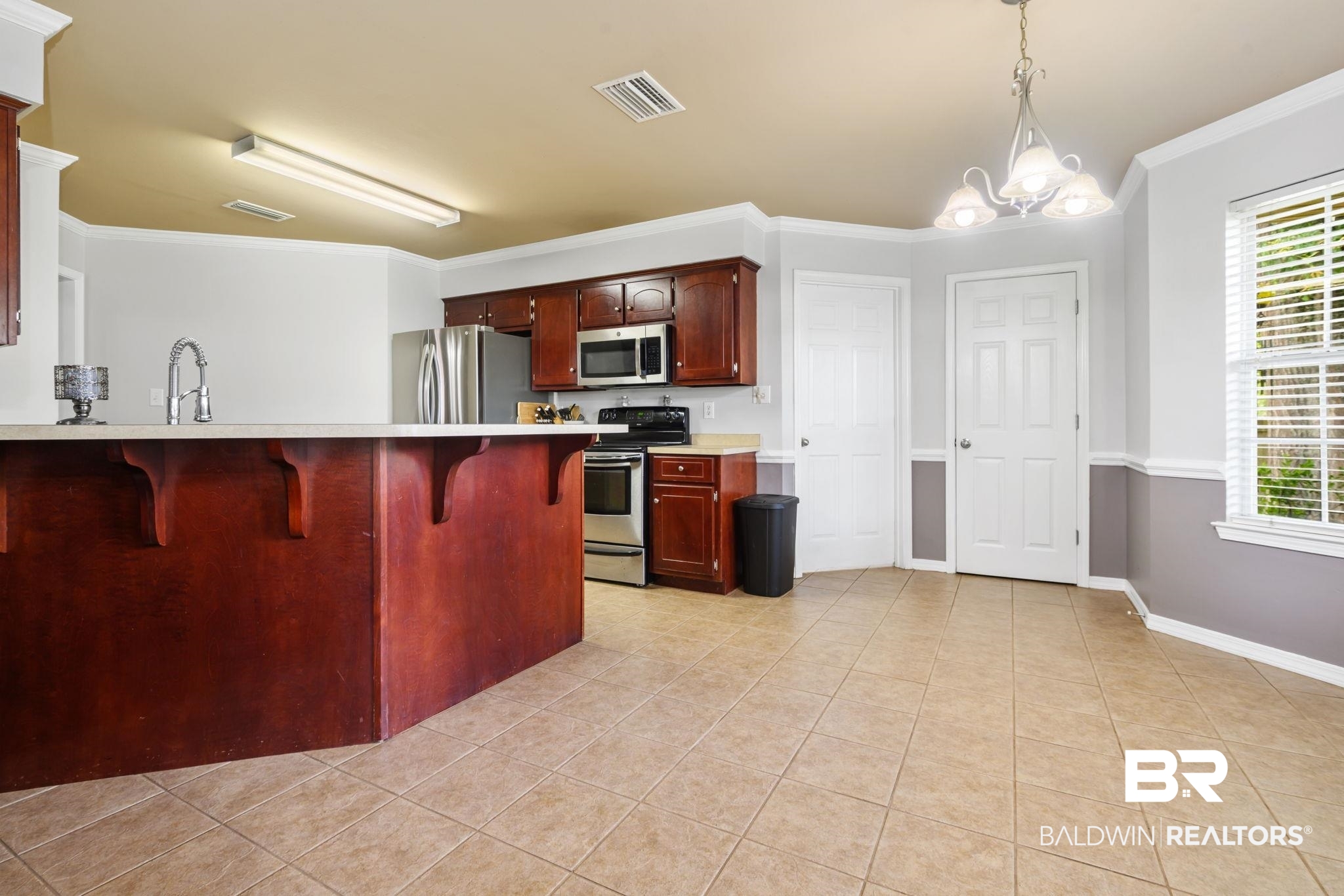 9422 Labrador Run South Mobile, AL 36695 - Photo 15 of 36 Kitchen featuring an expansive island with a light-toned countertop and a stainless steel gooseneck faucet