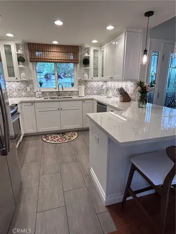 a kitchen with kitchen island granite countertop a sink a counter top space appliances and cabinets
